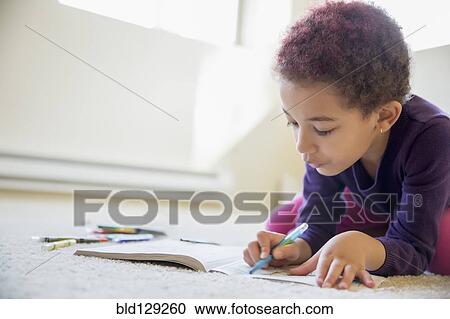 Stock Image - Mixed race girl coloring on floor. Fotosearch