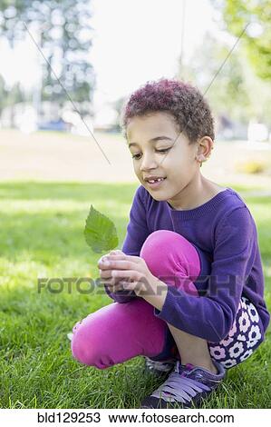 Mixed race girl examining leaf outdoors View Large Photo Image Stock Image - Mixed race girl examining leaf outdoors. Fotosearch