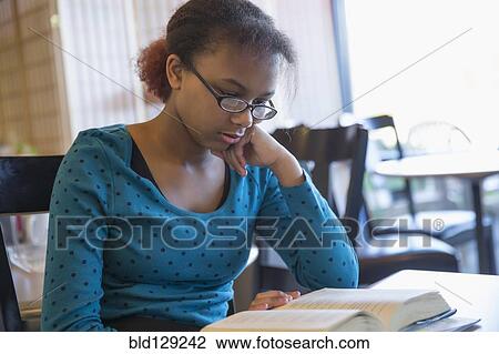 Mixed race girl reading book in cafe View Large Photo Image Stock Image - Mixed race girl reading book in cafe. Fotosearch