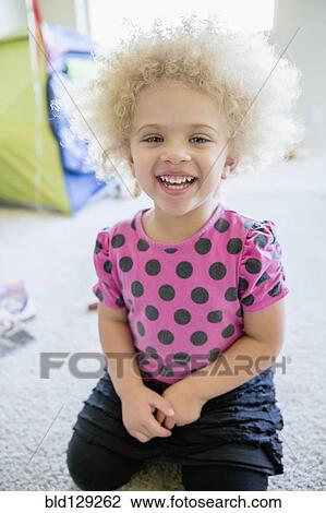 Mixed race girl smiling on bedroom floor View Large Photo Image Stock Image - Mixed race girl smiling on bedroom floor. Fotosearch