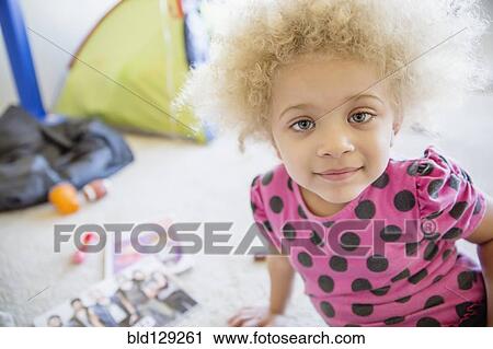 Mixed race girl smiling on floor View Large Photo Image Stock Image - Mixed race girl smiling on floor. Fotosearch