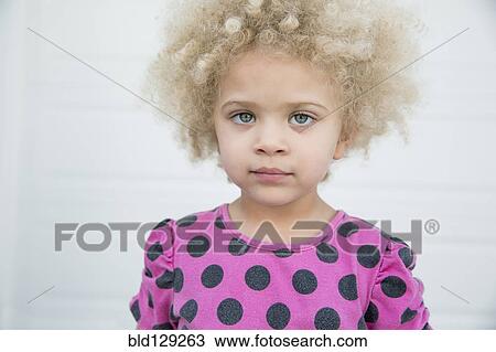 Stock Image - Mixed race girl standing outdoors. Fotosearch
