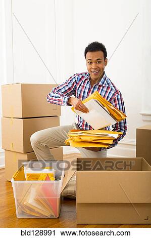 Mixed race man packing cardboard boxes View Large Photo Image Stock Image - Mixed race man packing cardboard boxes. Fotosearch