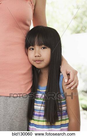 Stock Image - Mother and daughter hugging. Fotosearch