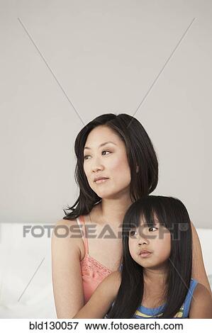 Mother and daughter sitting on bed View Large Photo Image Stock Photo - Mother and daughter sitting on bed. Fotosearch