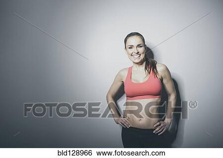 Stock Photograph - Portrait of smiling Caucasian woman in sports-bra. Fotosearch
