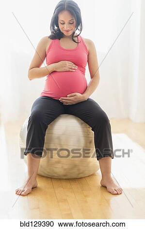 Pregnant Hispanic woman sitting on fitness ball View Large Photo Image Stock Image - Pregnant Hispanic woman sitting on fitness ball. Fotosearch