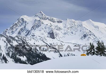 Stock Photo - Rocky mountain overlooking snowy landscape. Fotosearch