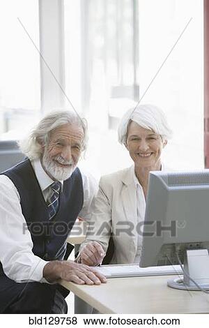 Senior Caucasian business people working together in office View Large Photo Image Stock Photo - Senior Caucasian business people working together in office. Fotosearch