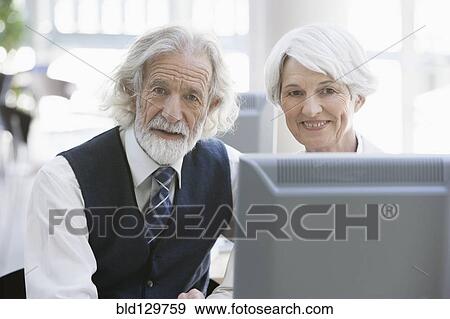 Senior Caucasian business people working together in office View Large Photo Image Stock Photo - Senior Caucasian business people working together in office. Fotosearch