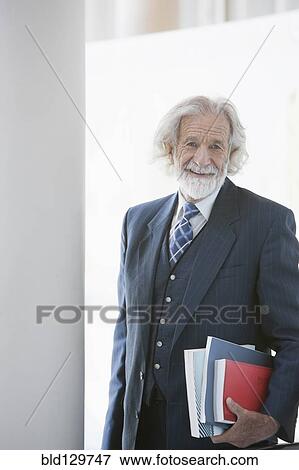 Senior Caucasian businessman carrying books View Large Photo Image Stock Photo - Senior Caucasian businessman carrying books. Fotosearch