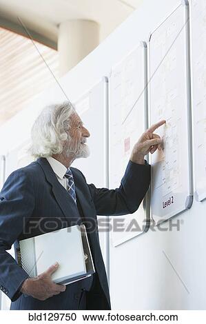 Senior Caucasian businessman reading directory View Large Photo Image Stock Image - Senior Caucasian businessman reading directory. Fotosearch