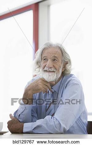 Senior Caucasian businessman smiling at desk View Large Photo Image Stock Photo - Senior Caucasian businessman smiling at desk. Fotosearch