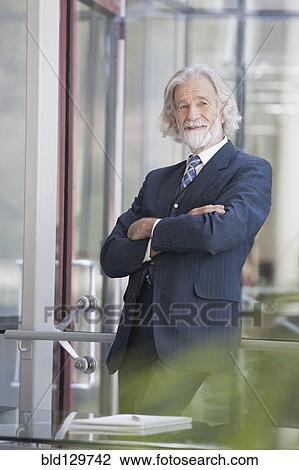 Stock Image - Senior Caucasian businessman smiling in office. Fotosearch