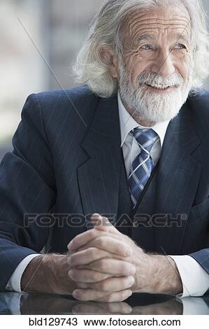 Stock Image - Senior Caucasian businessman smiling in office. Fotosearch