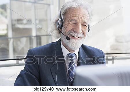 Senior Caucasian businessman talking on headset View Large Photo Image Stock Image - Senior Caucasian businessman talking on headset. Fotosearch