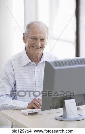 Senior Caucasian businessman working at desk View Large Photo Image Picture - Senior Caucasian businessman working at desk. Fotosearch