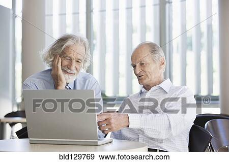Stock Photo - Senior Caucasian businessmen working together in office. Fotosearch