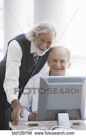 Stock Photograph - Senior Caucasian businessmen working together in office. Fotosearch
