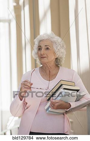 Senior Caucasian businesswoman carrying books View Large Photo Image Picture - Senior Caucasian businesswoman carrying books. Fotosearch