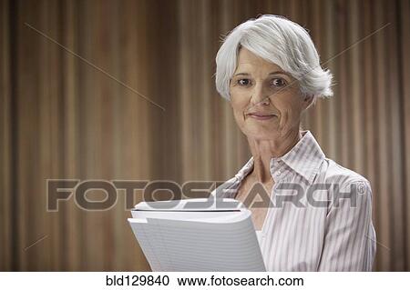 Stock Image - Senior Caucasian businesswoman holding notebook. Fotosearch