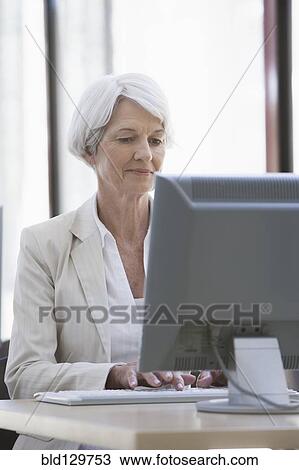 Senior Caucasian businesswoman working at desk View Large Photo Image Stock Image - Senior Caucasian businesswoman working at desk. Fotosearch
