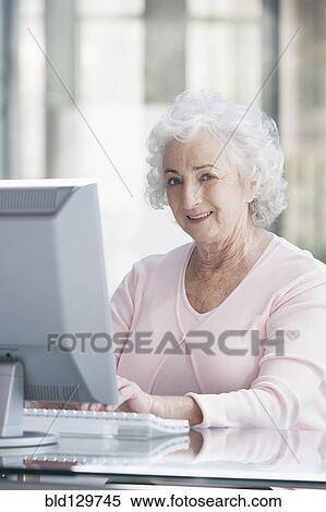 Senior Caucasian businesswoman working at desk View Large Photo Image Stock Photography - Senior Caucasian businesswoman working at desk. Fotosearch