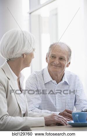 Stock Image - Senior Caucasian couple having coffee in cafe. Fotosearch