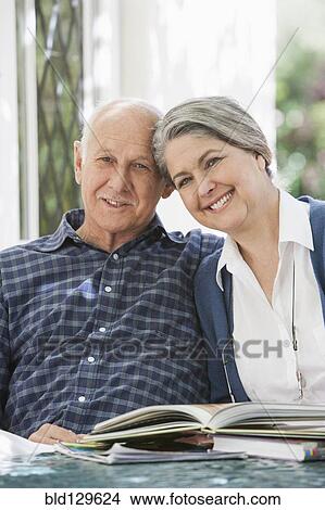 Picture - Senior Caucasian couple reading outdoors. Fotosearch