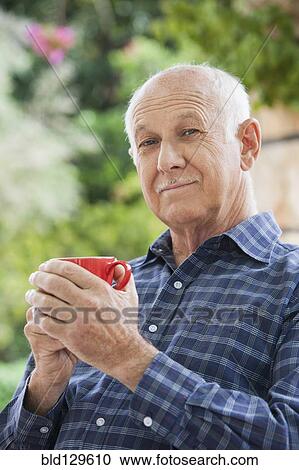 Senior Caucasian man having cup of coffee outdoors View Large Photo Image Stock Image - Senior Caucasian man having cup of coffee outdoors. Fotosearch
