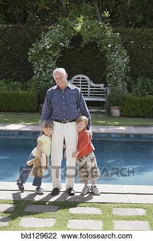 Senior Caucasian man hugging grandchildren by pool View Large Photo Image Stock Image - Senior Caucasian man hugging grandchildren by pool. Fotosearch