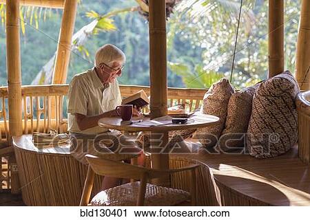Senior Caucasian man reading at patio table View Large Photo Image Stock Image - Senior Caucasian man reading at patio table. Fotosearch