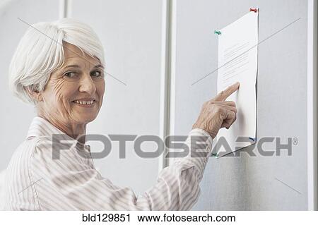 Stock Image - Senior Caucasian woman reading sign. Fotosearch