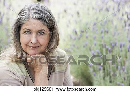 Stock Image - Senior Caucasian woman relaxing outdoors. Fotosearch