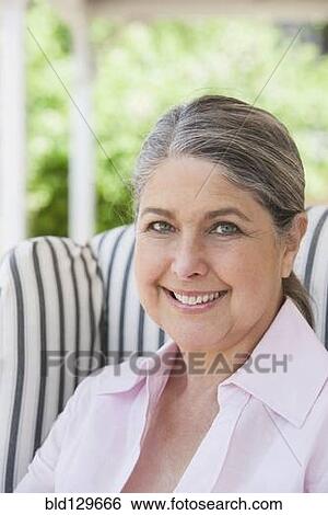 Stock Photograph - Senior Caucasian woman smiling on porch. Fotosearch