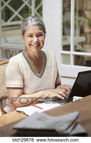 Stock Photo - Senior Caucasian woman working on laptop. Fotosearch