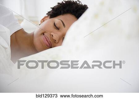 Serene Black woman laying in bed View Large Photo Image Stock Image - Serene Black woman laying in bed. Fotosearch