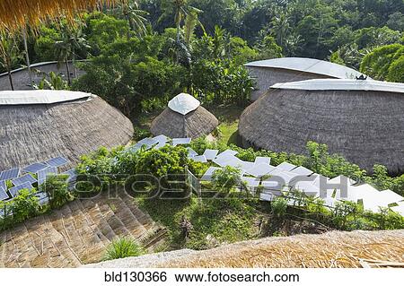 Solar panels among thatched roof buildings View Large Photo Image Stock Photograph - Solar panels among thatched roof buildings. Fotosearch