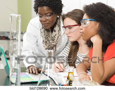 Stock Image - Students and teacher working in chemistry lab. Fotosearch