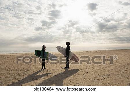 Surfers carrying boards on beach View Large Photo Image Picture - Surfers carrying boards on beach. Fotosearch