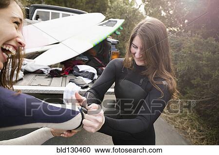 Surfers pulling on wet suits by truck View Large Photo Image Stock Image - Surfers pulling on wet suits by truck. Fotosearch