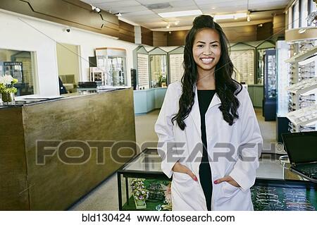 Picture - Vietnamese optometrist smiling in office. Fotosearch