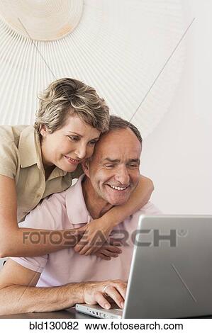 Woman hugging husband at laptop View Large Photo Image Stock Image - Woman hugging husband at laptop. Fotosearch