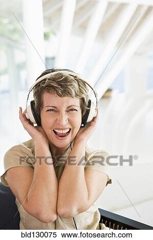 Stock Photography - Woman listening to headphones on stairs. Fotosearch