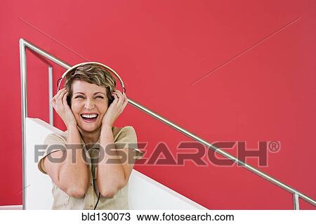 Woman listening to headphones View Large Photo Image Stock Image - Woman listening to headphones. Fotosearch