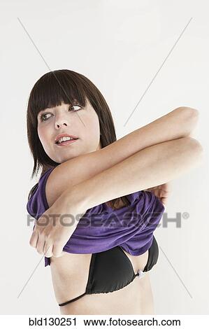 Woman pulling off shirt View Large Photo Image Stock Image - Woman pulling off shirt. Fotosearch