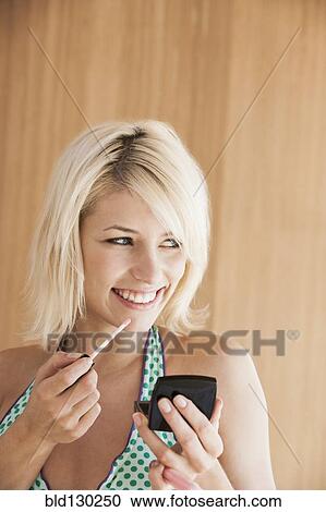 Woman putting on makeup View Large Photo Image Stock Image - Woman putting on makeup. Fotosearch