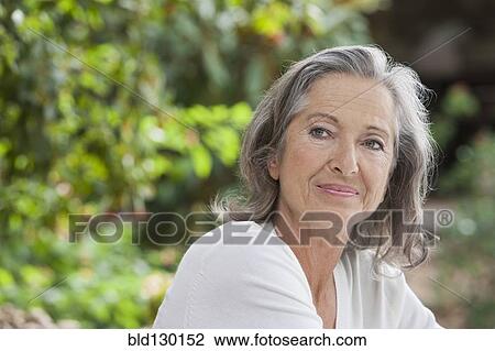 Woman sitting outdoors View Large Photo Image Stock Image - Woman sitting outdoors. Fotosearch