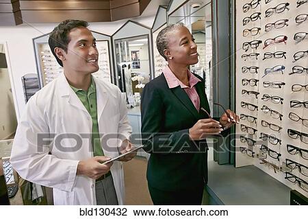 Woman trying on glasses at optometrist View Large Photo Image Stock Image - Woman trying on glasses at optometrist. Fotosearch