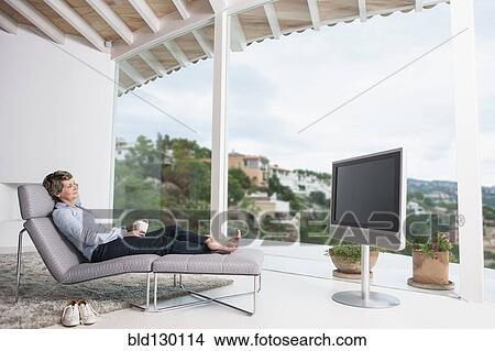 Picture - Woman watching television in living room. Fotosearch